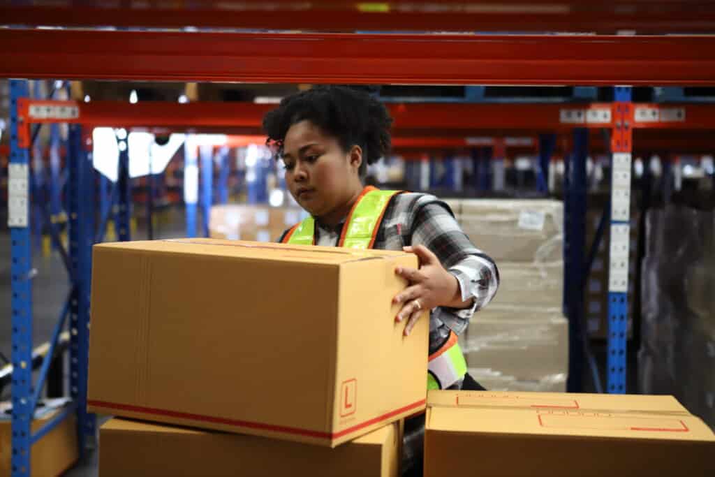 Portrait of worker in warehouse , they  happy and  working at The Warehouse. Storehouse area, Shipment.  warehouse worker unloading pallet goods in warehouse